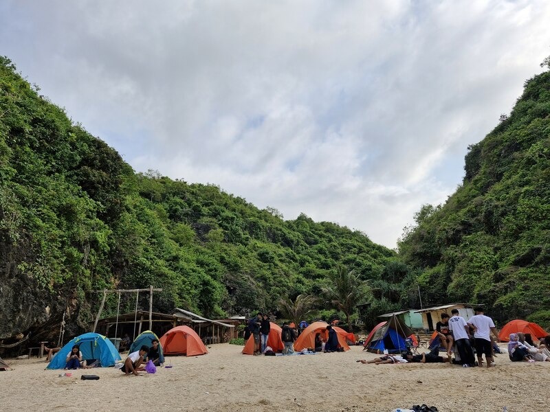 Area camping Pantai Wohkudu dengan tebing karst sebagai dinding alami pelindung angin di Gunungkidul